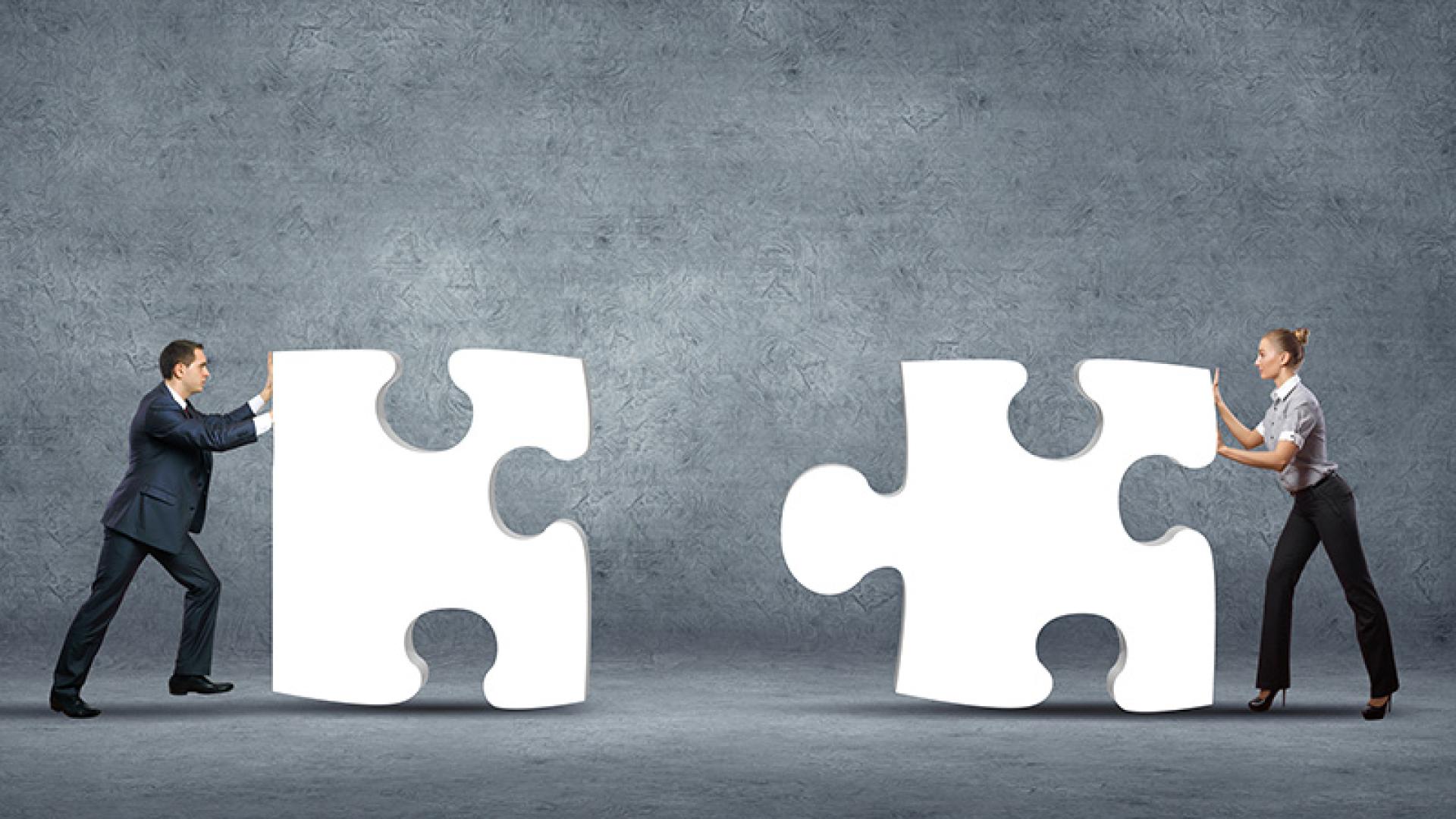 2 mensen met reuze puzzelstukken