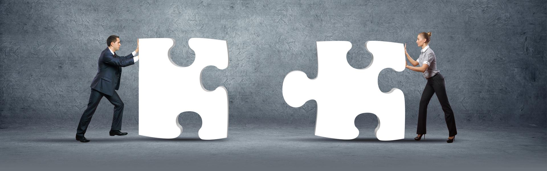 2 mensen met reuze puzzelstukken